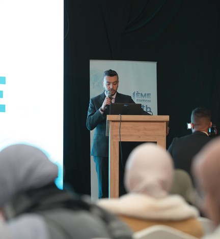 Un intervenant au pupitre pendant une conférence