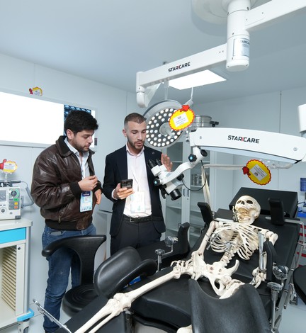 Des visiteurs devant un fauteuil d'examen et un squelette de démonstration