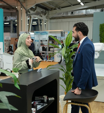 Une exposante échange avec un visiteur sur son stand